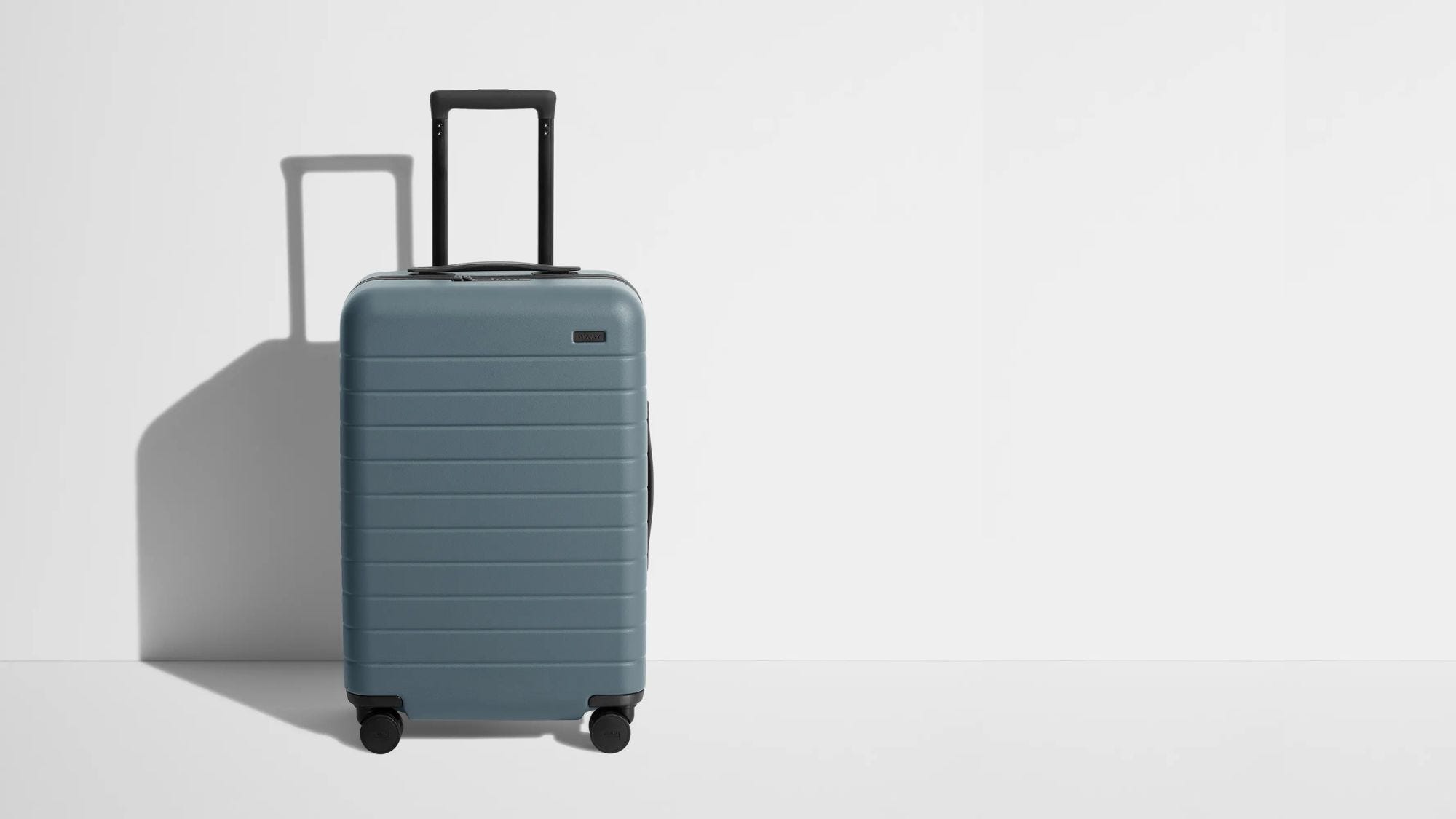 blueish-grey suitcase against a grey background